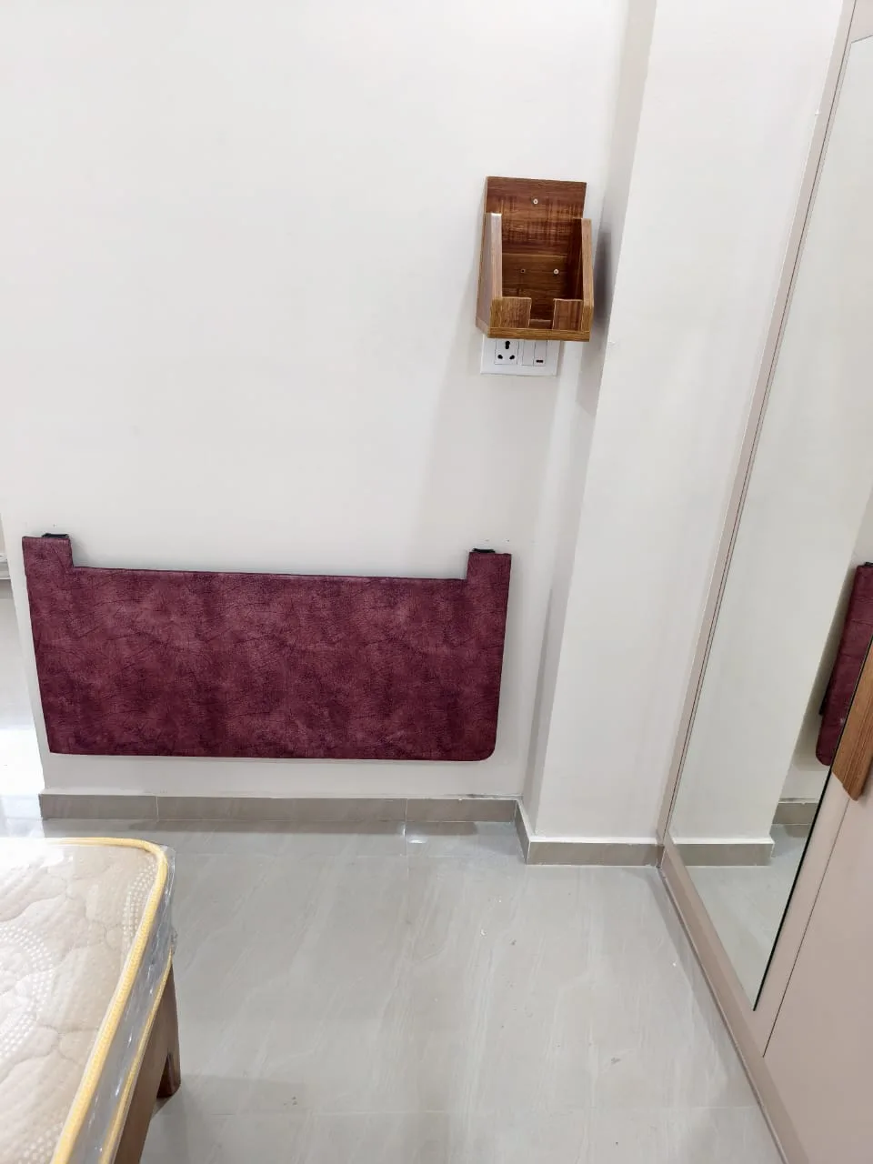 Maroon iron table folded flat beside a bedroom wardrobe
